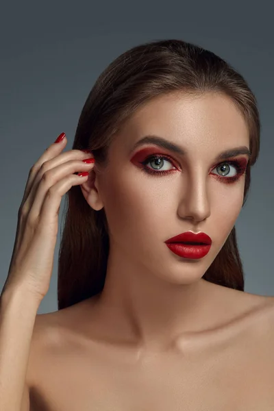 Glamour-Porträt in Großaufnahme eines schönen halbnackten Models mit hellem Make-up, das vor grauem Hintergrund posiert. — Stockfoto