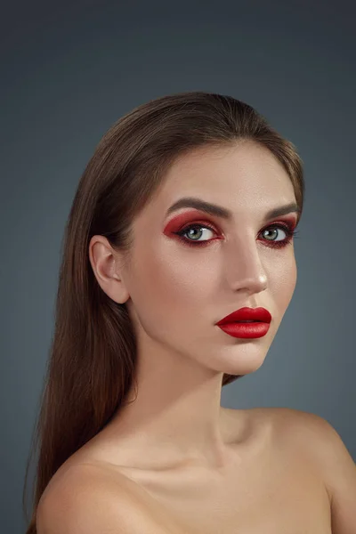 Glamour-Porträt in Großaufnahme eines schönen halbnackten Models mit hellem Make-up, das vor grauem Hintergrund posiert. — Stockfoto