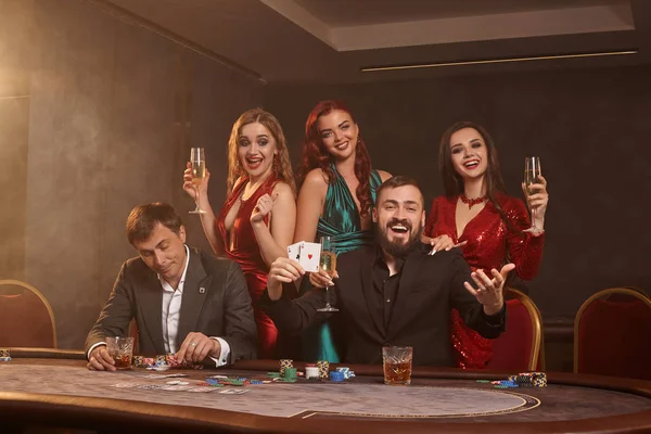 Skupina mladých bohatých přátel hrají poker v kasinu. — Stock fotografie