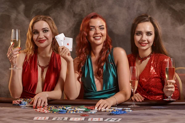 Skupina mladých bohatých dam hrají poker v kasinu. — Stock fotografie