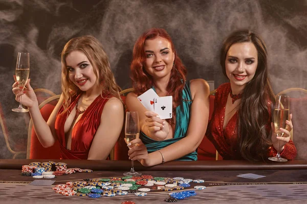 Skupina mladých bohatých dam hrají poker v kasinu. — Stock fotografie