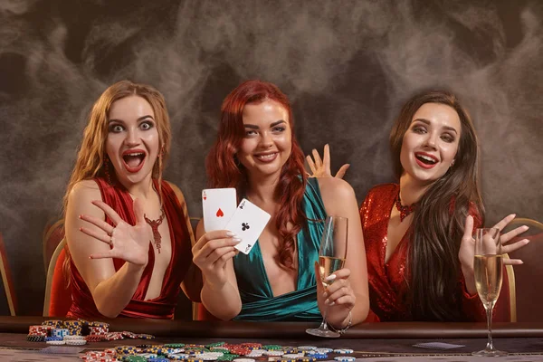 Skupina mladých bohatých dam hrají poker v kasinu. — Stock fotografie