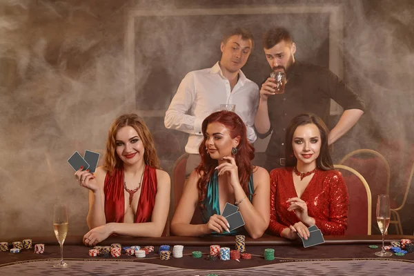 Grupo de jovens amigos ricos estão jogando poker em um cassino . — Fotografia de Stock