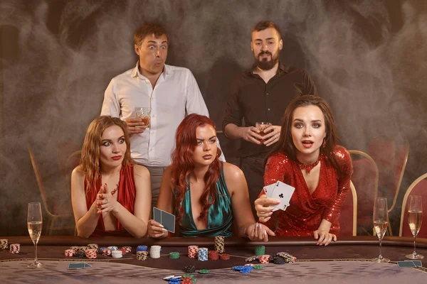 Grupo de jóvenes amigos ricos están jugando al póquer en un casino . — Foto de Stock