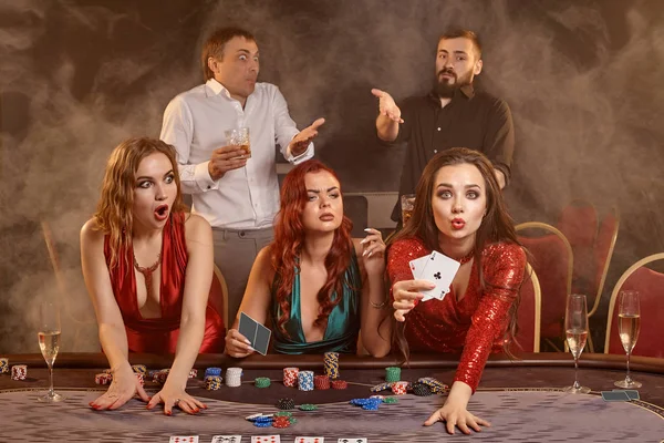 Group of a young wealthy friends are playing poker at a casino. — Stock Photo, Image