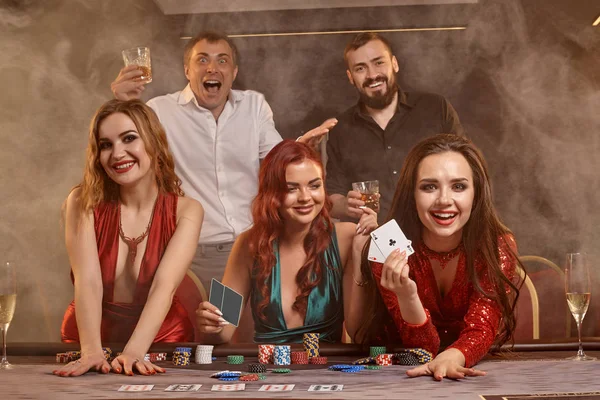 Gruppo di giovani amici ricchi stanno giocando a poker in un casinò . — Foto Stock