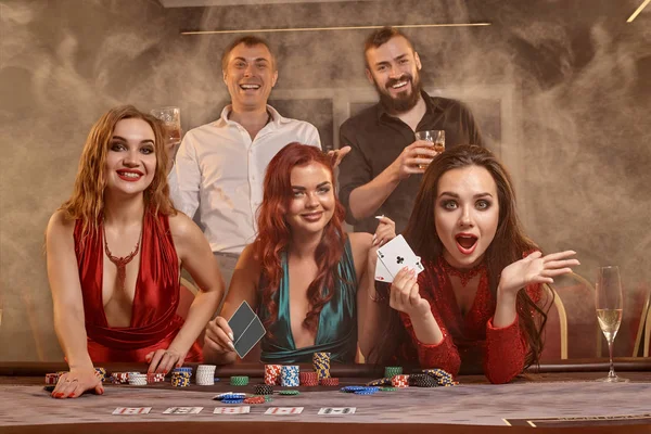 Group of a young wealthy friends are playing poker at a casino. — Stock Photo, Image