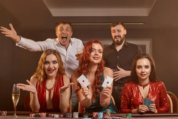 Group of a young wealthy friends are playing poker at a casino. — Stock Photo, Image