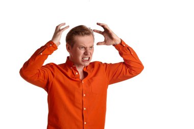 Tarz sahibi turuncu tişörtlü, genç, modaya uygun bir zencefilin yakın plan portresi. Beyaz stüdyo arka planında yalnız poz verirken öfkeden deliye dönmüş gibi davranıyor. İnsan yüz ifadeleri. Samimi duygular konsepti. Boşluğu kopyala.