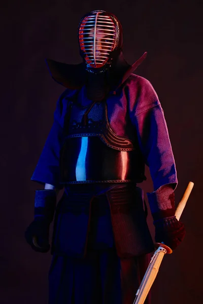 Nahaufnahme, Kendo-Kämpfer in Rüstung, traditioneller Kimono, Helm als Kampfkunst mit Shinai-Bambusschwert, schwarzer Hintergrund. — Stockfoto