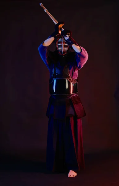 Крупный план, боец Кендо в доспехах, традиционное кимоно, шлем практикующий боевое искусство с бамбуковым мечом Синай, черный фон . — стоковое фото