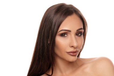 Profesyonel akşam makyajı ve dolgun dudakları olan, beyaz arka planda izole edilmiş esmer, çıplak model bir kızın yakın portresi..