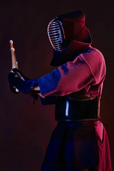 Κοντινό πλάνο, Kendo μαχητής φορώντας μια πανοπλία, παραδοσιακό κιμονό, κράνος εξάσκηση πολεμικές τέχνες με Shinai μπαμπού σπαθί, μαύρο φόντο. — Φωτογραφία Αρχείου
