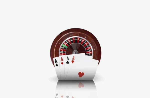 Close-up photo of four aces standing ahead of a brown roulette, isolated on white background. Playing cards. Gambling entertainment. — Stock Photo, Image