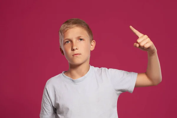티셔츠를 꼬마의 클로즈업 손가락을 분홍색 스튜디오 배경을 배경으로 포즈를 취하는 — 스톡 사진