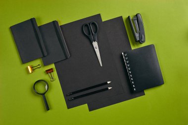 Ofis ekipmanları, malzemeler ve kırtasiye malzemeleriyle en iyi görüntü. Kopyalama alanı olan yeşil arkaplan. Eğitim, işyeri konsepti. Yakın plan..