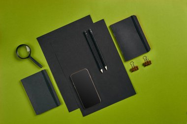 Ofis ekipmanları, malzemeler ve kırtasiye malzemeleriyle en iyi görüntü. Kopyalama alanı olan yeşil arkaplan. Eğitim, işyeri konsepti. Yakın plan..