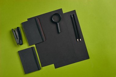 Ofis ekipmanları, malzemeler ve kırtasiye malzemeleriyle en iyi görüntü. Kopyalama alanı olan yeşil arkaplan. Eğitim, işyeri konsepti. Yakın plan..