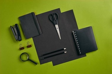 Ofis ekipmanları, malzemeler ve kırtasiye malzemeleriyle en iyi görüntü. Kopyalama alanı olan yeşil arkaplan. Eğitim, işyeri konsepti. Yakın plan..