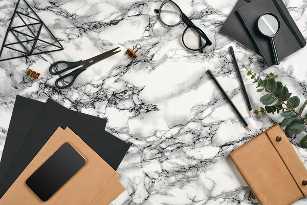 Top view in focus with different office equipment, supplies, stationery. Marble table with copy space. Education, workplace background. Close-up.