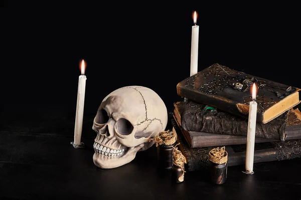 Realistický model lidské lebky se zuby na dřevěném tmavém stole, černé pozadí. Lékařská věda nebo halloweenský horor. Detailní záběr. — Stock fotografie