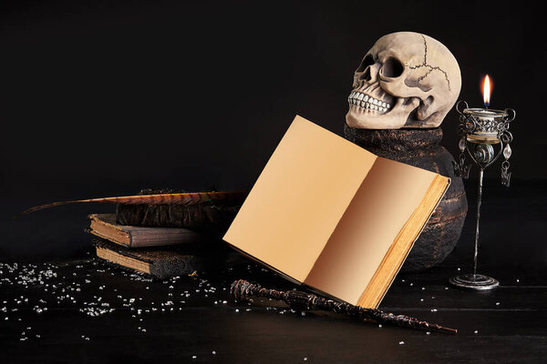 Realistic model of a human skull with teeth on a wooden dark table, black background. Medical science or Halloween horror concept. Close-up shot.