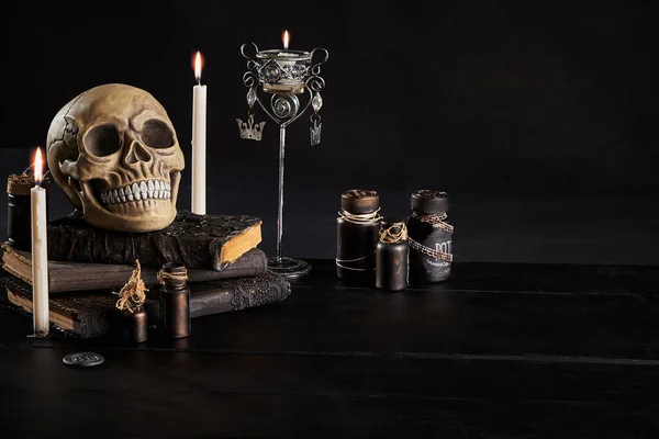 Ρεαλιστικό μοντέλο ανθρώπινου κρανίου με δόντια σε ξύλινο σκούρο τραπέζι, μαύρο φόντο. Ιατρική επιστήμη ή αποκριάτικη φρίκη. Κοντινό πλάνο.. — Φωτογραφία Αρχείου