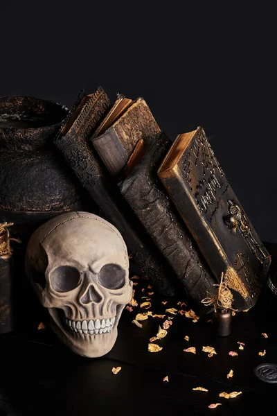 Realistisch model van een menselijke schedel met tanden op een houten donkere tafel, zwarte achtergrond. Medische wetenschap of Halloween horror concept. Close-up opname. — Stockfoto