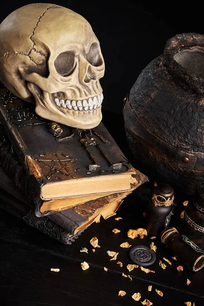 Realistický model lidské lebky se zuby na dřevěném tmavém stole, černé pozadí. Lékařská věda nebo halloweenský horor. Detailní záběr. — Stock fotografie