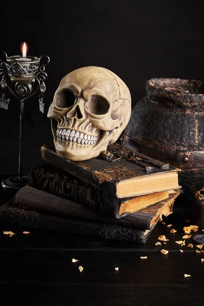 Realistisch model van een menselijke schedel met tanden op een houten donkere tafel, zwarte achtergrond. Medische wetenschap of Halloween horror concept. Close-up opname. — Stockfoto