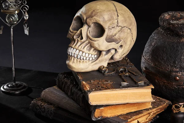 Realistic model of a human skull with teeth on a wooden dark table, black background. Medical science or Halloween horror concept. Close-up shot. — Stock Photo, Image