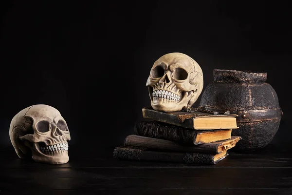 Realistisch model van een menselijke schedel met tanden op een houten donkere tafel, zwarte achtergrond. Medische wetenschap of Halloween horror concept. Close-up opname. — Stockfoto