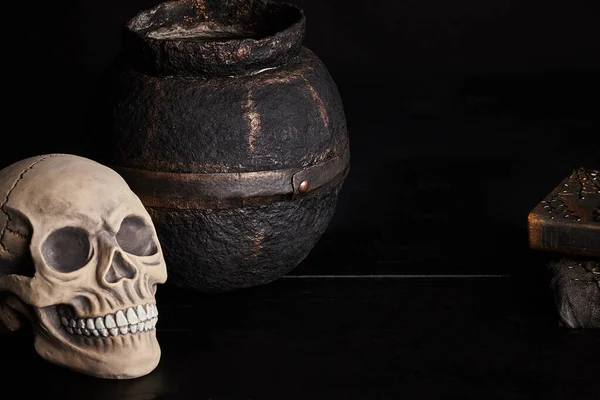 Realistisch model van een menselijke schedel met tanden op een houten donkere tafel, zwarte achtergrond. Medische wetenschap of Halloween horror concept. Close-up opname. — Stockfoto