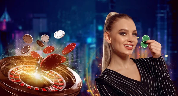 Blonde girl in black dress. Smiling, showing two green chips, posing on colorful background with roulette and flying chips. Poker, casino. Close-up — Stock Photo, Image