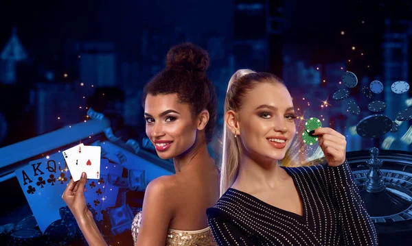 Young models are smiling, showing two green chips and aces. Posing on colorful background with roulette and flying chips. Poker, casino. Close-up — Stock Photo, Image