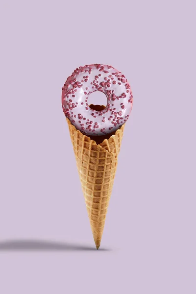 Sprinkled and glazed donut in sweet wafer cone on lilac background. Food, treats and unhealthy nutrition. Close up, copy space — Stock Photo, Image