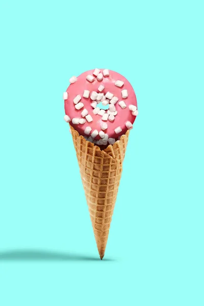Doce donut envidraçado por gelo rosa polvilhado com marshmallow em cone wafer em fundo turquesa. Doces, nutrição insalubre. Fechar, espaço de cópia — Fotografia de Stock