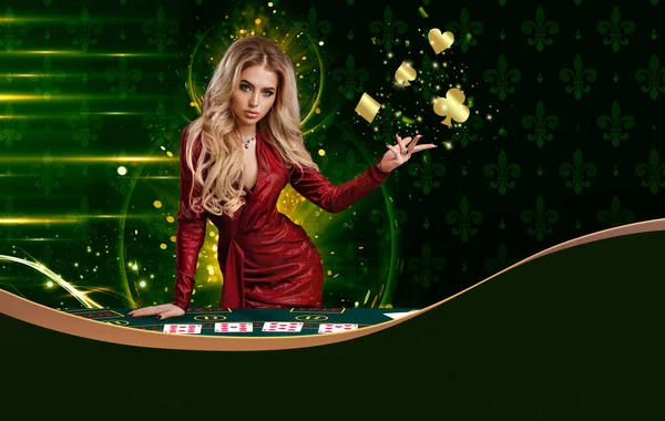 Kırmızı elbiseli sarışın kadın altın renkli kart takımları gösteriyor, oyun masasına yaslanıyor, renkli arka planda poz veriyor. Uzayı kopyala Poker, kumarhane — Stok fotoğraf
