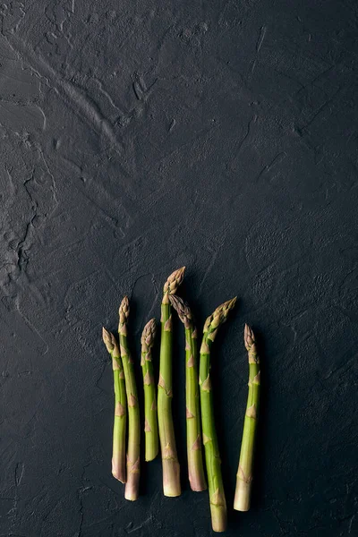 绿色生芦笋在黑色石板背景上长出长矛.健康食品的概念和春季蔬菜的收成.关闭，复制空间 — 图库照片