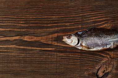 Bir kurutulmuş ya da kurutulmuş salamura hamamböceği, ahşap zemin üzerinde lezzetli bir kırpıntı balığı. Tuzlu bira mezesi. Geleneksel balık koruma yöntemi. Kapat.