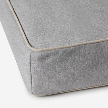 Gri bir şiltenin köşesine yakın plan, bej boruları vurguluyor, yatak takımlarını sergilemek için mükemmel.