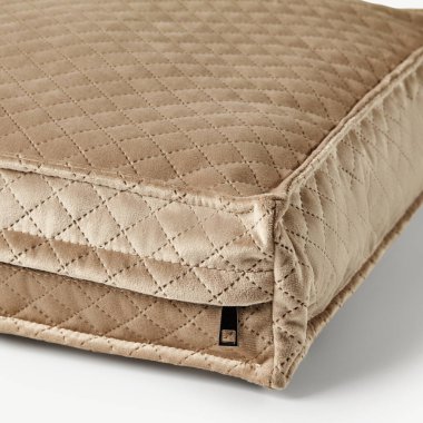 Elmas desenli bej kadife bir yastığın yakın çekimi. Dikiş, dokusu ve işçiliği vurgulanıyor.