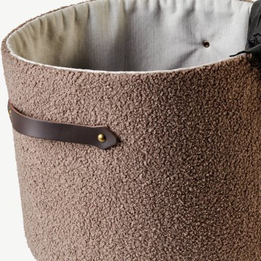 Modern silindirik, içi boş çamaşır sepeti deri saplı ve görünür iç kumaşlı.