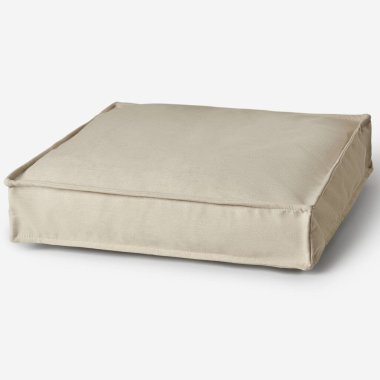 Boş bej köpek yatağı beyaz arka planda dinleniyor, evcil hayvanlar için rahat ve rahatlatıcı bir uyku sunuyor.