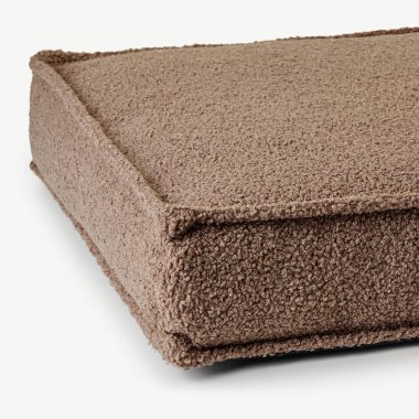 Yumuşak, desenli, kahverengi döşeme minderinin yakın çekimi, sıcacık ve davetkar doğasını vurguluyor.