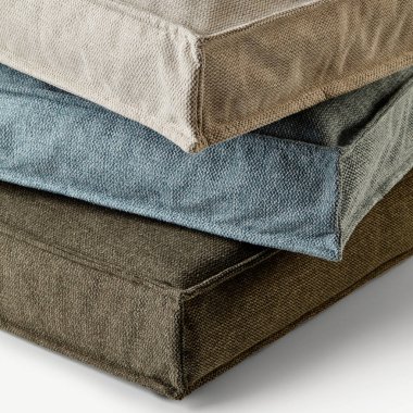 Beyaz arkaplana istiflenmiş rahat kare yastıklar rahat ve rahatlatıcı bir atmosfer yaratıyor