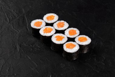 Somon ve pirinçle doldurulmuş taze suşi dürümleri görsel olarak çekici bir mutfak deneyimi yaratıyor.