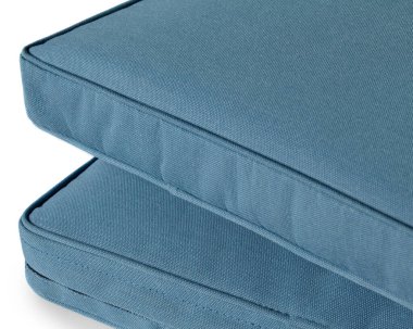 İki açık mavi kare yastık beyaz arka planda istiflenmiş, kumaş dokularını ve dikişlerini sergiliyorlar.