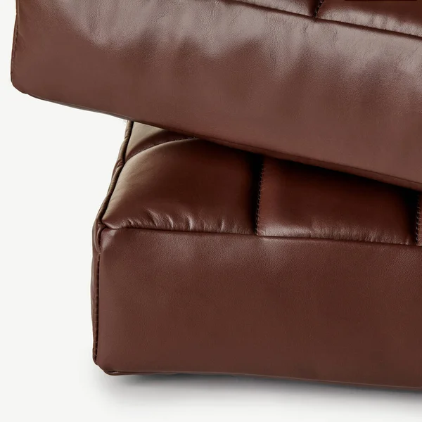 Kaliteli dikiş ve işçiliğin altını çizen iki adet kahverengi deri yastığın yakın çekimi