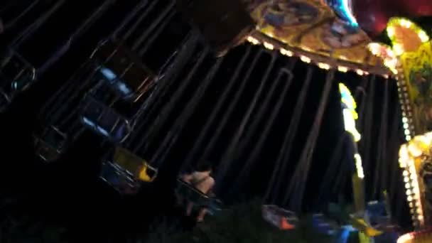 Une vue de nuit d'un beau carrousel clignotant dans un parc d'attractions — Video